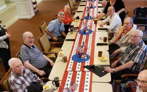 Group of senior men celebrate the Fourth of July during a group dinner at senior living community in Cincinnati, Ohio.