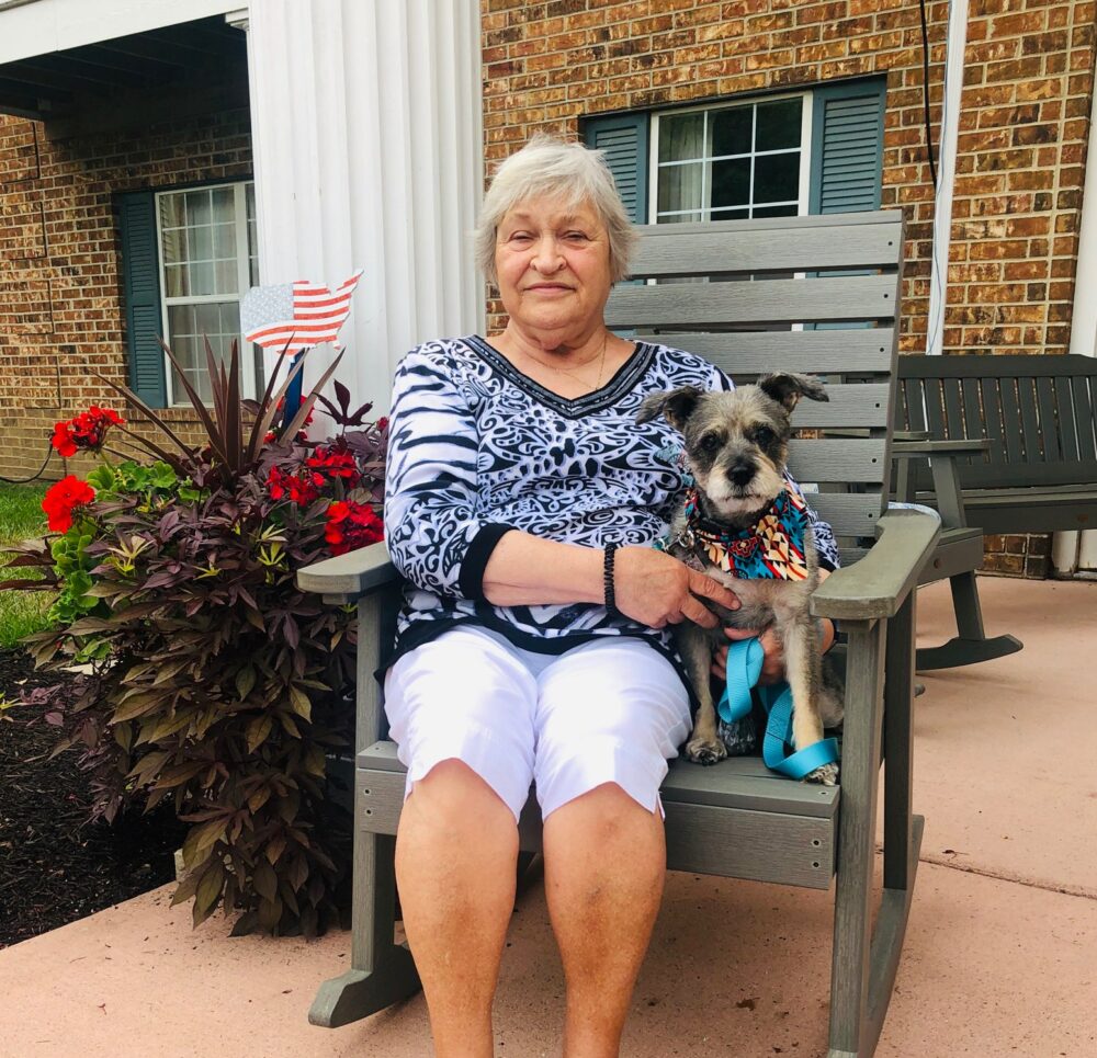 Senior woman sits with her small pet dog at a senior living community in Fort Wayne, Indiana.