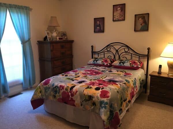 Model bedroom with bed, dresser and nightstand at a senior living community in Rochester, Indiana.