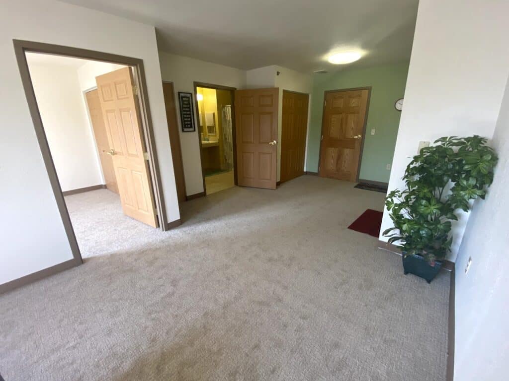 Apartment entry way with doors to other rooms at a senior living facility in Hartford, Wisconsin.