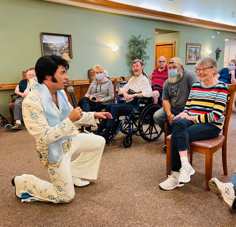 An Elvis impersonator performs for a group of seniors