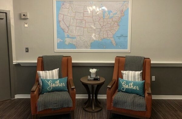 Two seats in front of a world map in a lounge area at a senior living community in College Station, Texas.