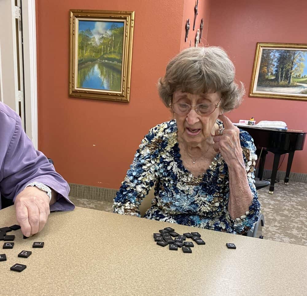 Senior woman plays Scrabble at the Courtyards at Lake Granbury, a senior living community in Granbury, Texas.