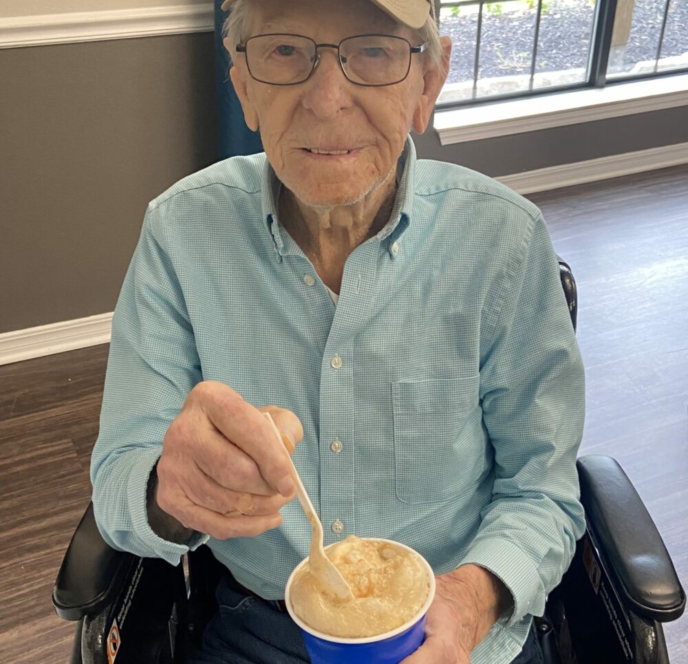 Senior man smiles with a root beer float at a senior living community in College Station, Texas.