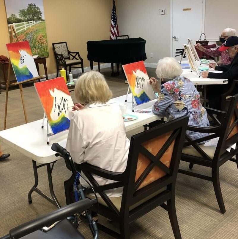Seniors painting a canvas during a class at a senior living community located in Ridgeland, Mississippi.