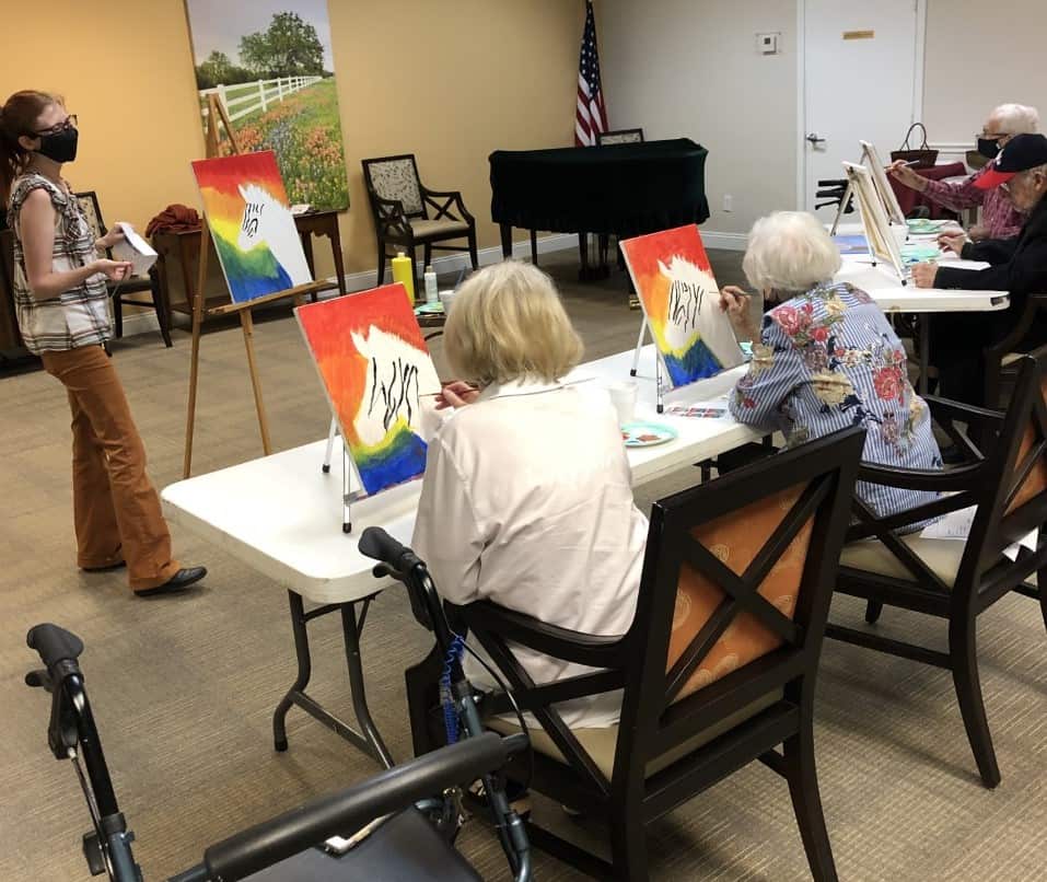 Seniors painting a canvas during a class at a senior living community located in Ridgeland, Mississippi.