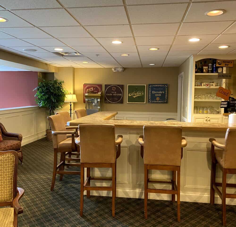 Pub area in senior living community in Cincinnati, Ohio with bar, stools and television.