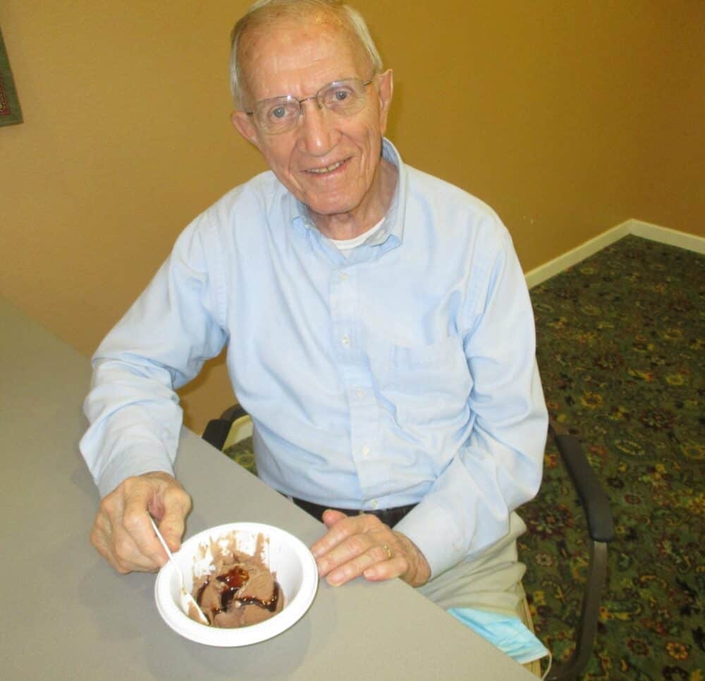 Senior man smiles with a bowl of ice cream at a senior community in Perrysburg, Ohio.