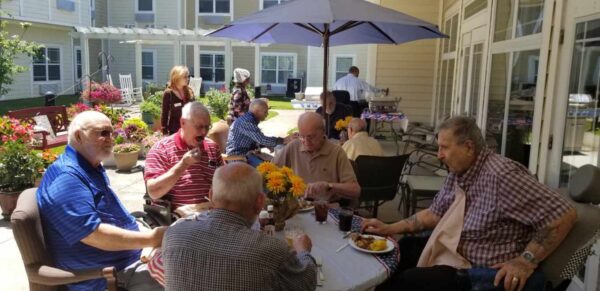 Group of senior men eat together outside at a senior living community in Dayton, Ohio.