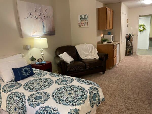 Studio apartment with bed, kitchenette and couch at senior living community in Columbus, Ohio.