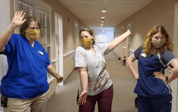 Three senior living caregivers acting silly.