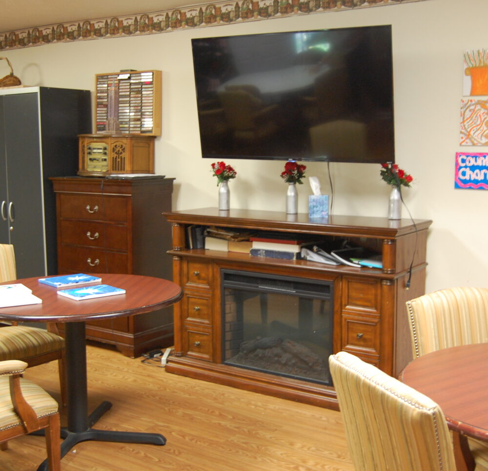 Activity center with a large screen TV and sitting area at a senior living community in Greenwood, Indiana.