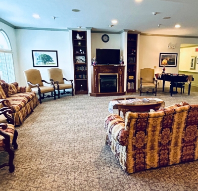 Lounge area with couches, chairs, a TV and piano