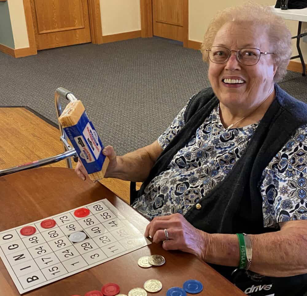 Senior woman smiles while playing Bingo at a senior living facility in Colby, Wisconsin.