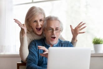 Couple acts shocked by something they see on computer.