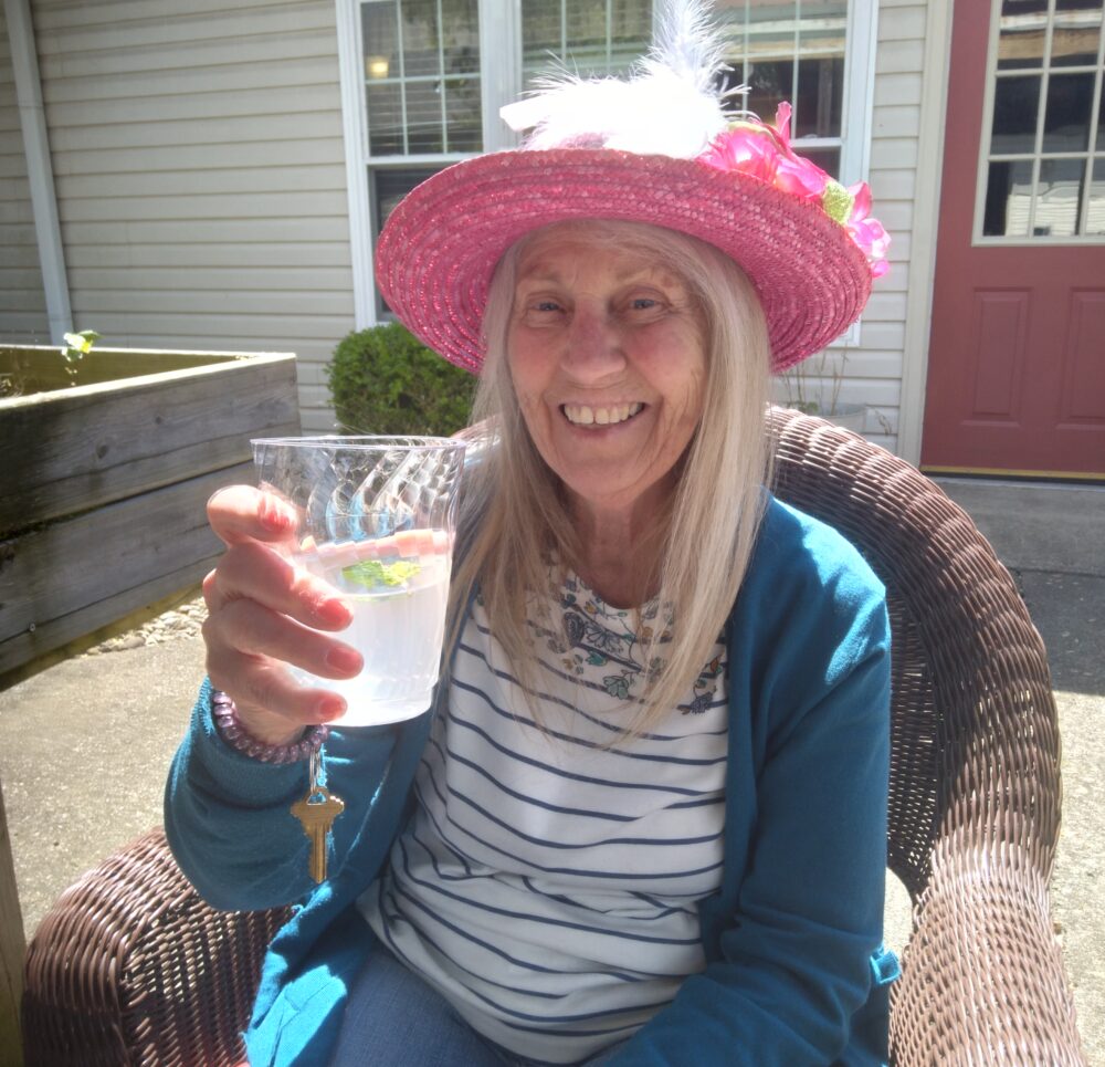 Senior woman celebrates the Kentucky Derby with a festive drink at a senior living community in Jeffersonville, Indiana.