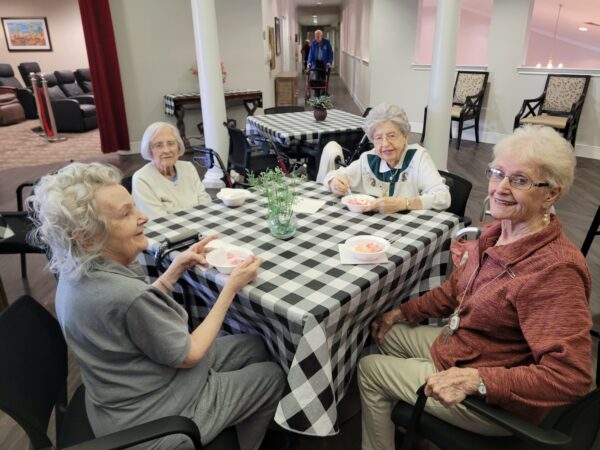 four senior women smile while they eat ice cream together in Fort Worth