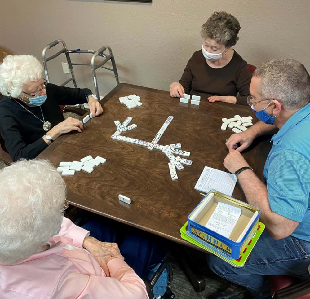 Group of seniors playing a game at a table at a senior living facility in Richardson, Texas.
