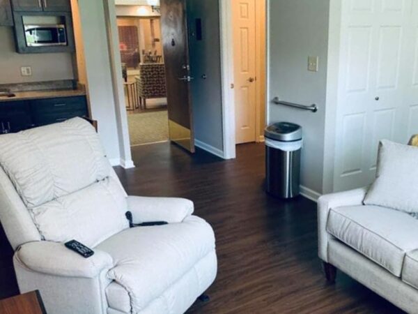 a chair and couch inside a studio apartment at The Harrison