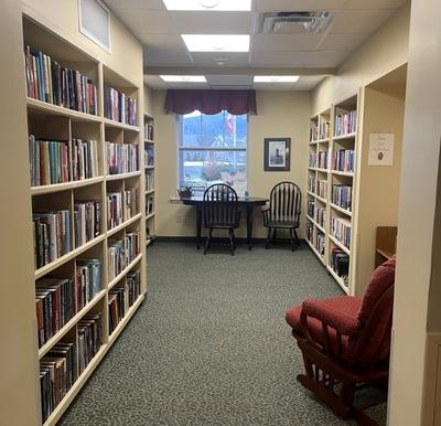 A well-stocked library with comfortable seating near a window in Oneonta, New York