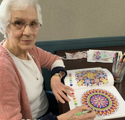 Senior woman coloring at a senior living community in Oneonta, New York.