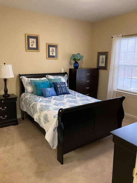 Model bedroom at a senior living community in Macedonia, Ohio with full size bed, nightstand and dresser.