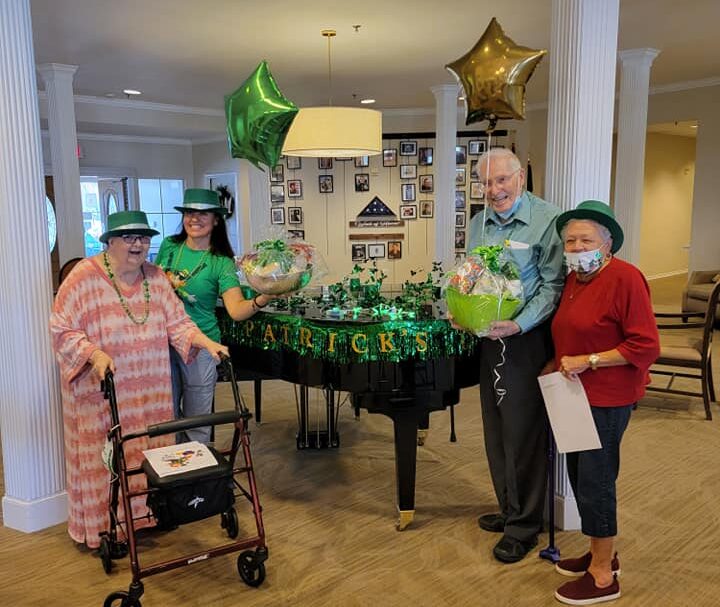 Seniors pose by the piano during St. Patrick's day at the Waterford at Thousand Oaks in San Antonio, Texas.