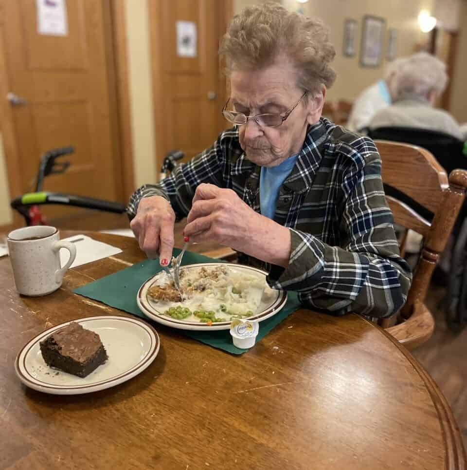 Senior woman eats a meal while at a senior living community, located in Park Falls, Wisconsin.