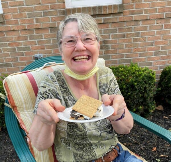 Senior woman smiling with her smore treat at a senior living community in Greencastle, Indiana.