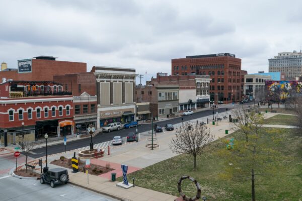 Felix Street Square in downtown St. Joseph, MIssouri. View of cars parked, sculptures, and local business in the background.