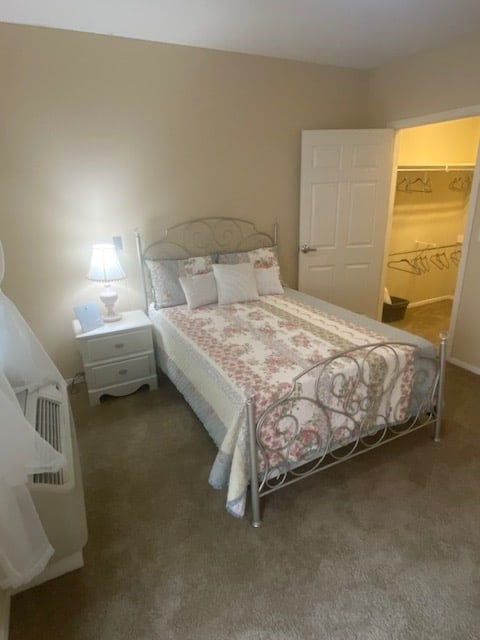 Studio apartment with queen bed, side table, closet and window
