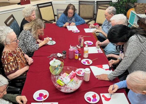 large group of seniors paint together for Valentines Day