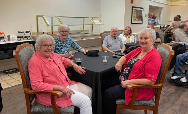 a group of seniors enjoy live entertainment together while seated at a table