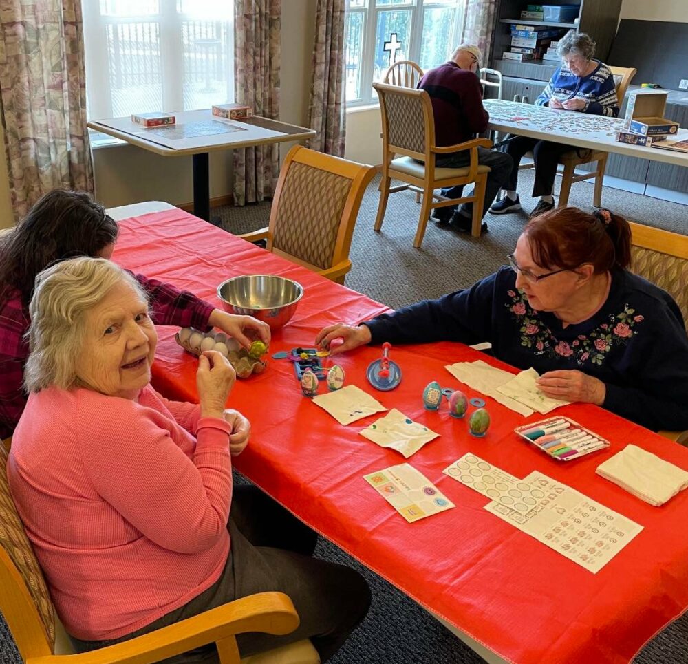 two senior women dye eggs on easter
