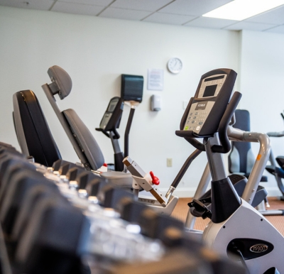 fitness center inside a senior living community with bikes and weight equipment