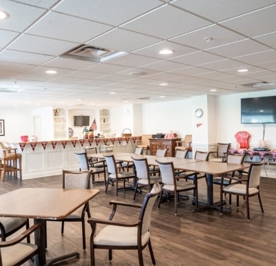 senior living community pub with tables and chairs and a TV
