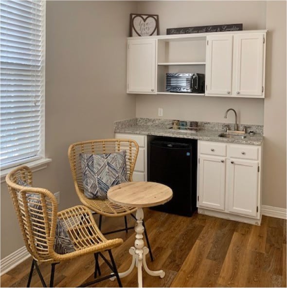 A clean model apartment kitchenette with a bistro dining set in Arlington, Texas.