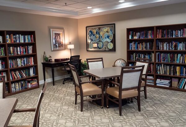 A large library with multiple tables, a desk and many bookshelves in Williamsville, New York.