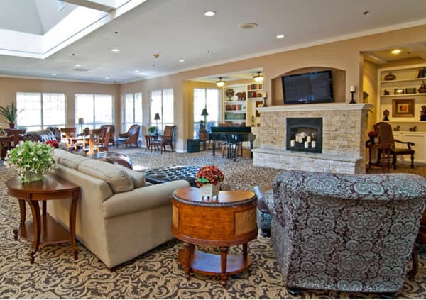 A great room with a fireplace, piano, library and comfortable sofas in Arlington, Texas.