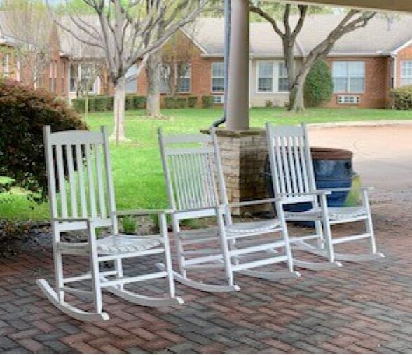 Senior living community rocking chairs in outdoor courtyard in Arlington, Texas.
