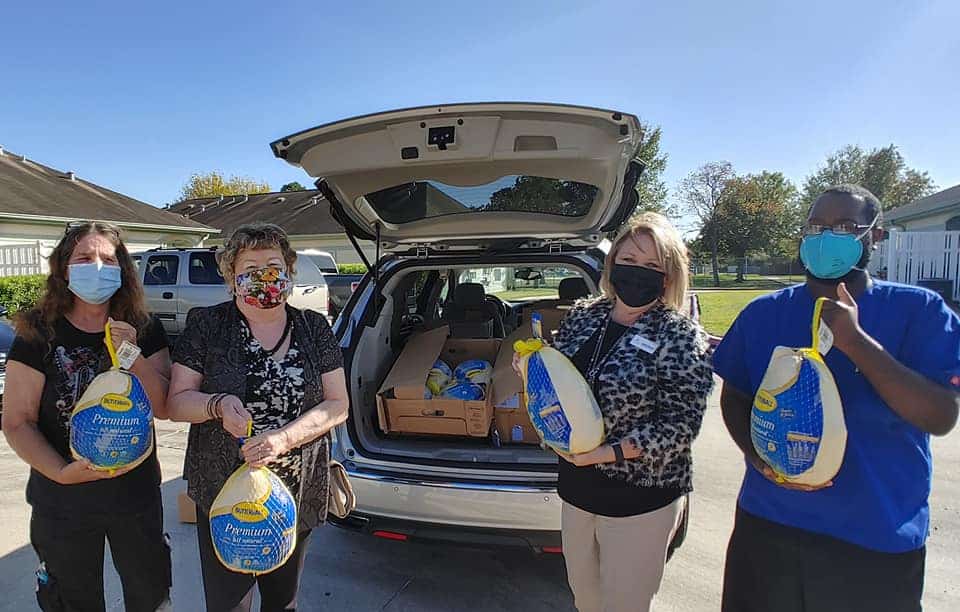 Group of employees distribute turkeys to residents of Senior Living Facility.