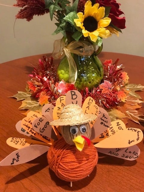 Thanksgiving turkey centerpiece with a vase full of Fall flowers.