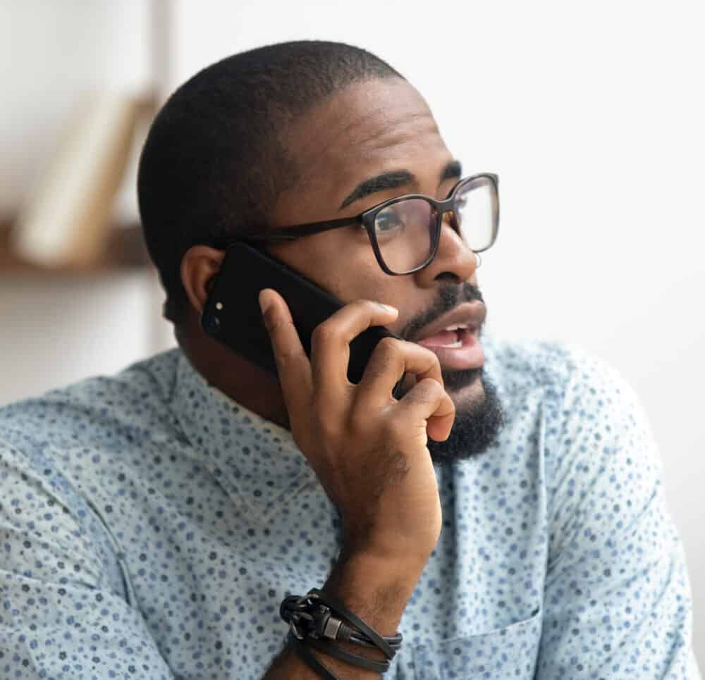 Close up of man talking phone at workplace in office.