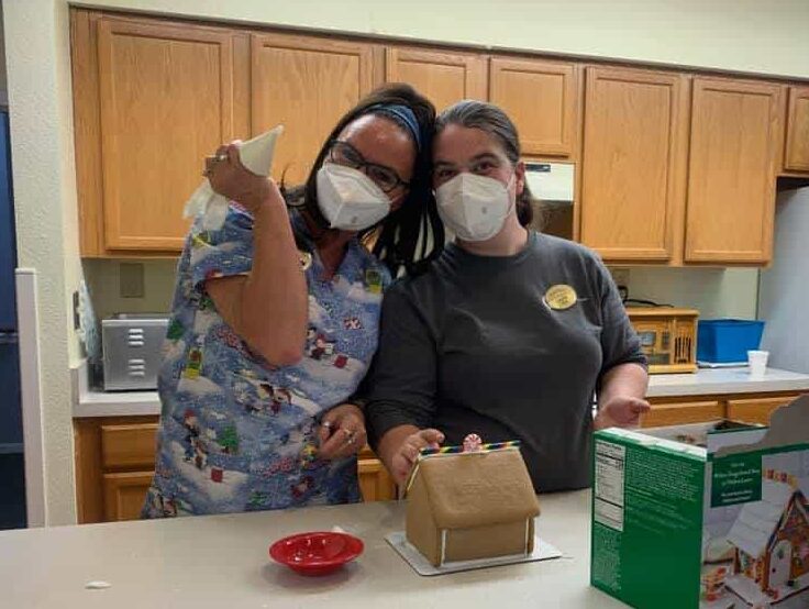 Two employees of senior living facility make a gingerbread house in Jeffersonville, Indiana.