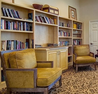 A well-stocked library in The Waterford at Corpus Christi, complete with gold velour, plush lounge chairs in Corpus Christi, Texas..