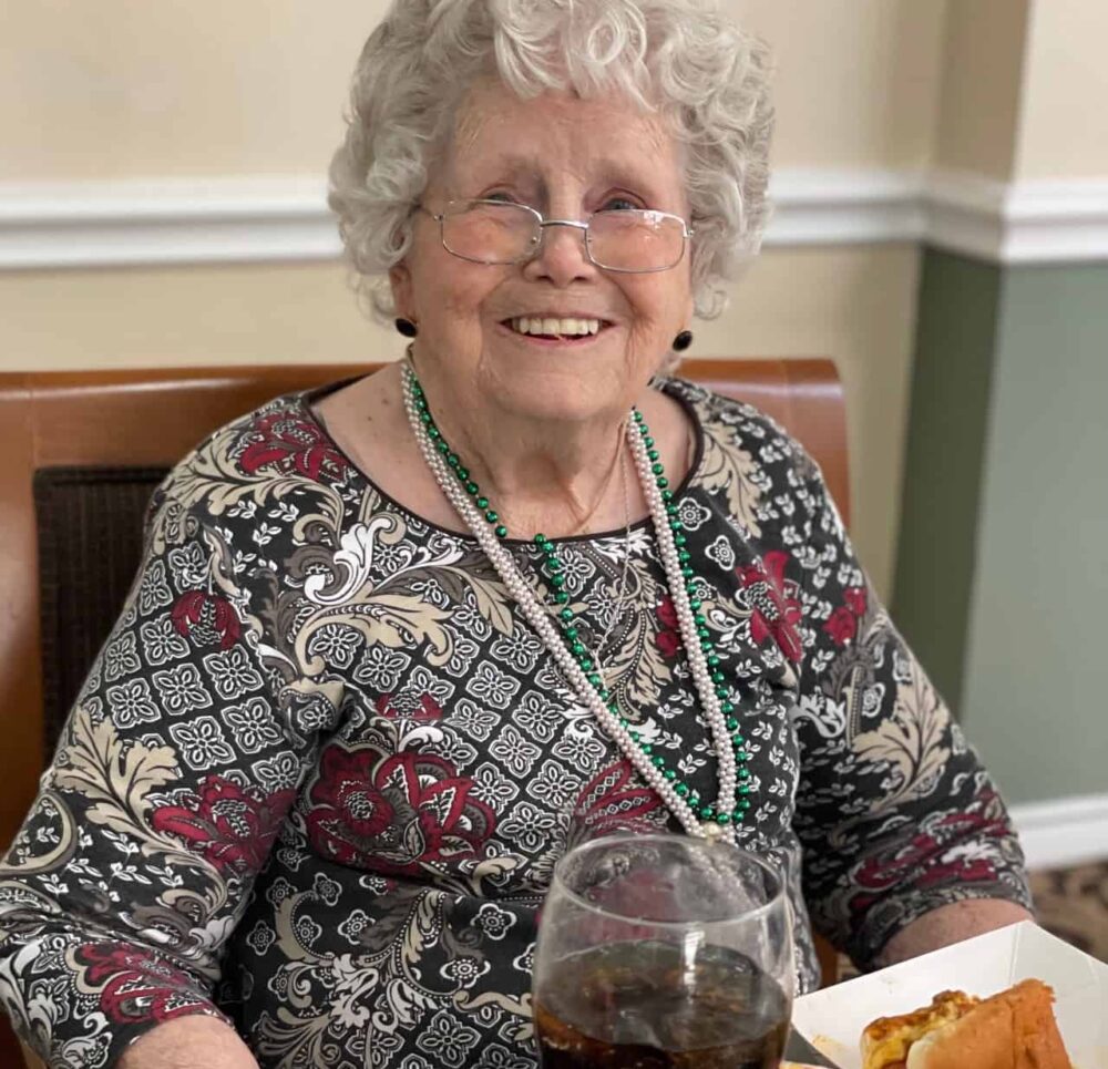 Senior woman smiling with her food at senior living facility in Corpus Christi, Texas.