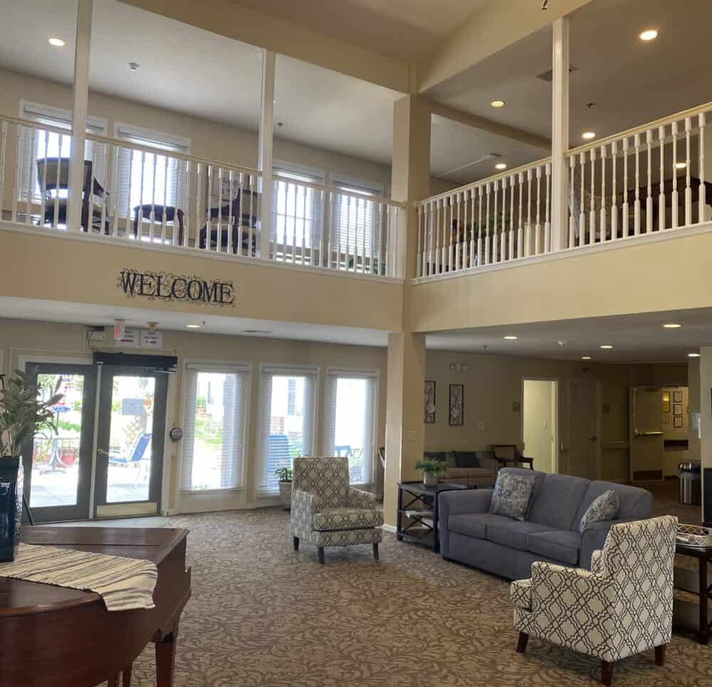 Two story lobby with sitting area and piano at senior living community in Omaha, Nebraska.