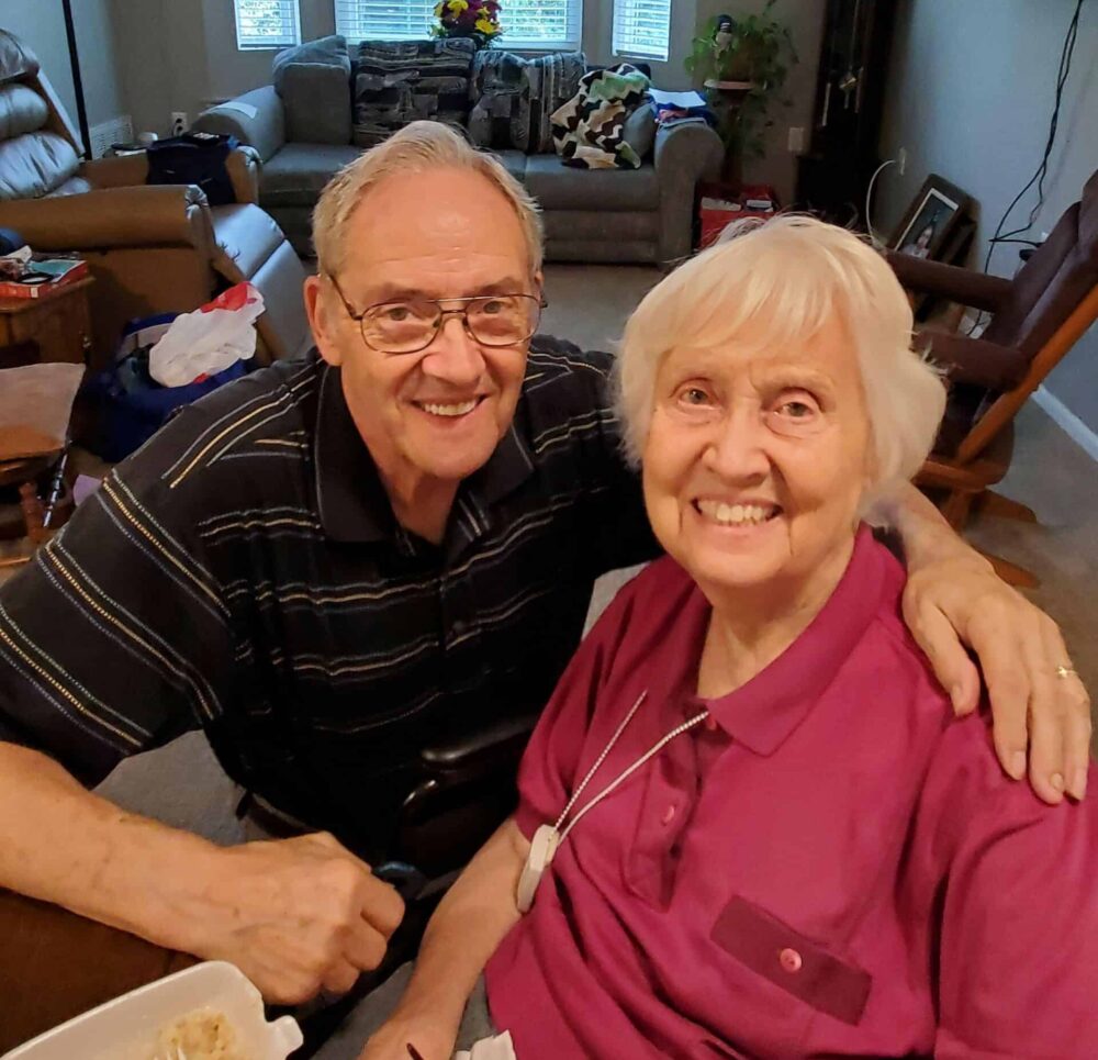 Two seniors smiling at the camera at a senior living community in Lincoln, Nebraska.