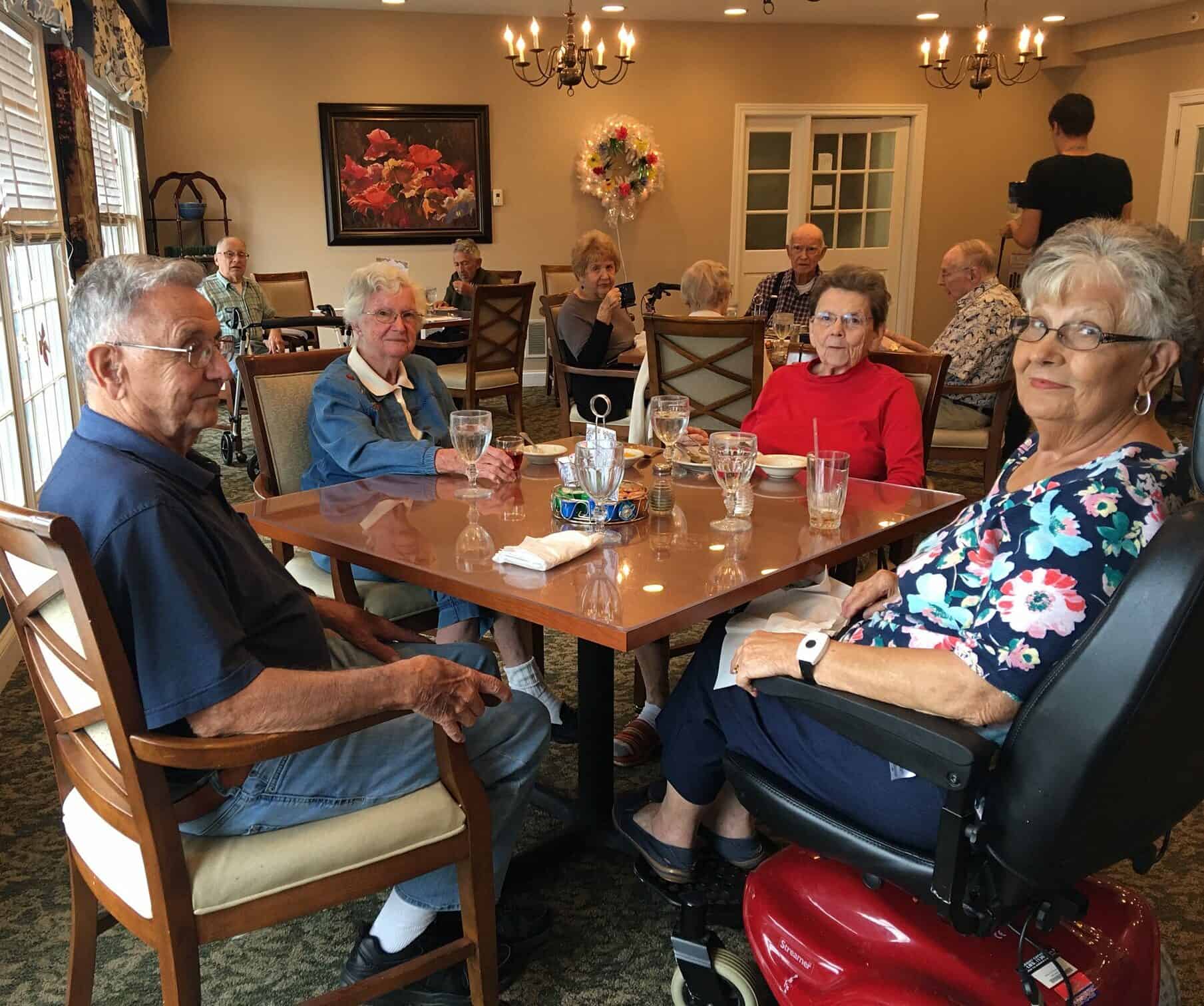 Four seniors eat together at a table in Wynnfield Crossing, a senior community in Rochester, Indiana