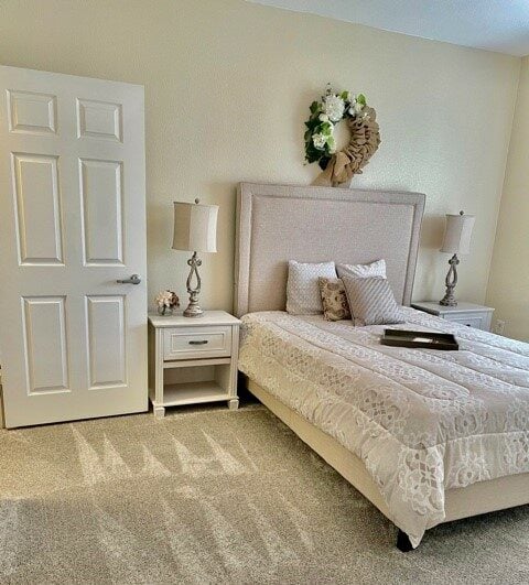 A model apartment bedroom with a bed and nightstands at a senior community in Fort Worth, Texas.